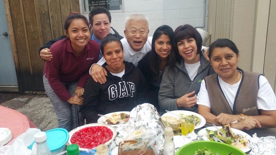 Group of friends posing for camera with food in front of table